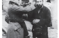 Two German soldiers publicly humiliate a religious Jew in Skarżysko Kamienna by cutting off his sidelocks, 1939-1940. ©United States Holocaust Memorial Museum Photo Archives